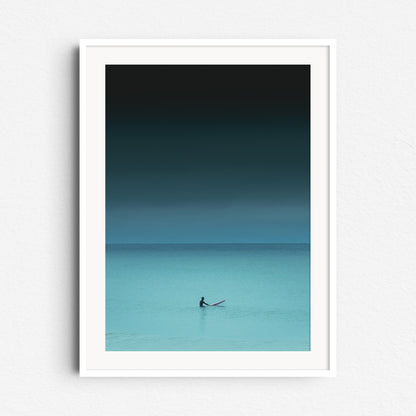 Serene turquoise photo of a surfer waiting in the North Sea. Framed surf artwork in white wood, adding a calming vibe to your space.