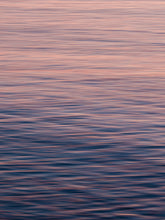 Load image into Gallery viewer, Close up of a calm north sea surface with an orange and purple glow.
