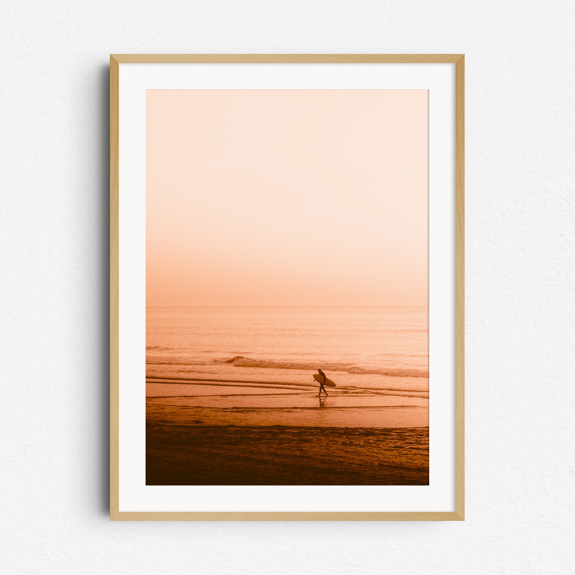 A surfer walks back from a surf session in the North Sea. Nature photography from The Netherlands framed in natural wood. Captured by Jop Hermans