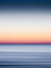 Load image into Gallery viewer, Orange and blue long exposure photograph of a sunset over the north sea. Using the panning technique to give the ocean surface a smooth, soft effect.
