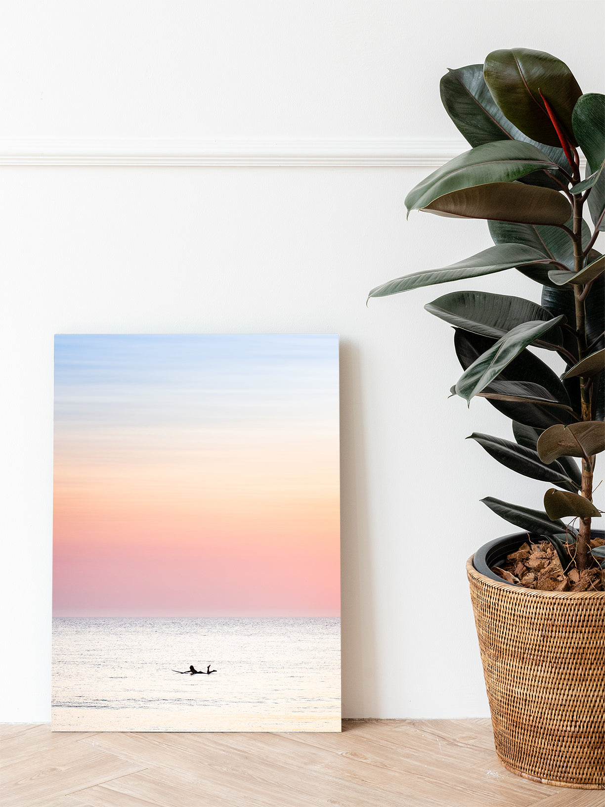 Pastel Dutch summer surfing printed on dibond, standing on a livingroom floor next to a green plant. Beautiful wall-art.