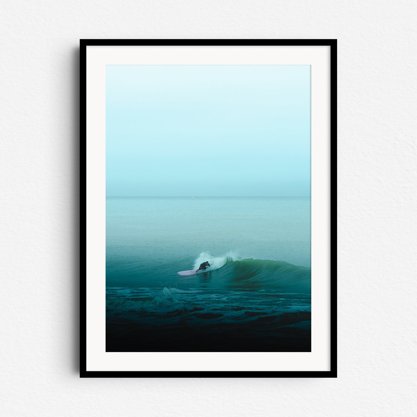 Minimalistic surf photo with a striking pink longboard against turquoise waves. Framed in black wood for modern artwork.