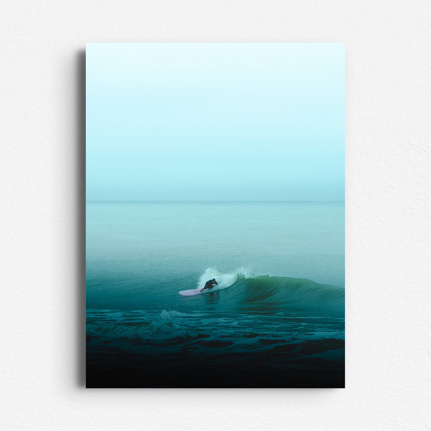 A minimalistic Scheveningen surf photo with turquoise hues and a pink longboard. Printed on Dibond for sleek wall decoration.