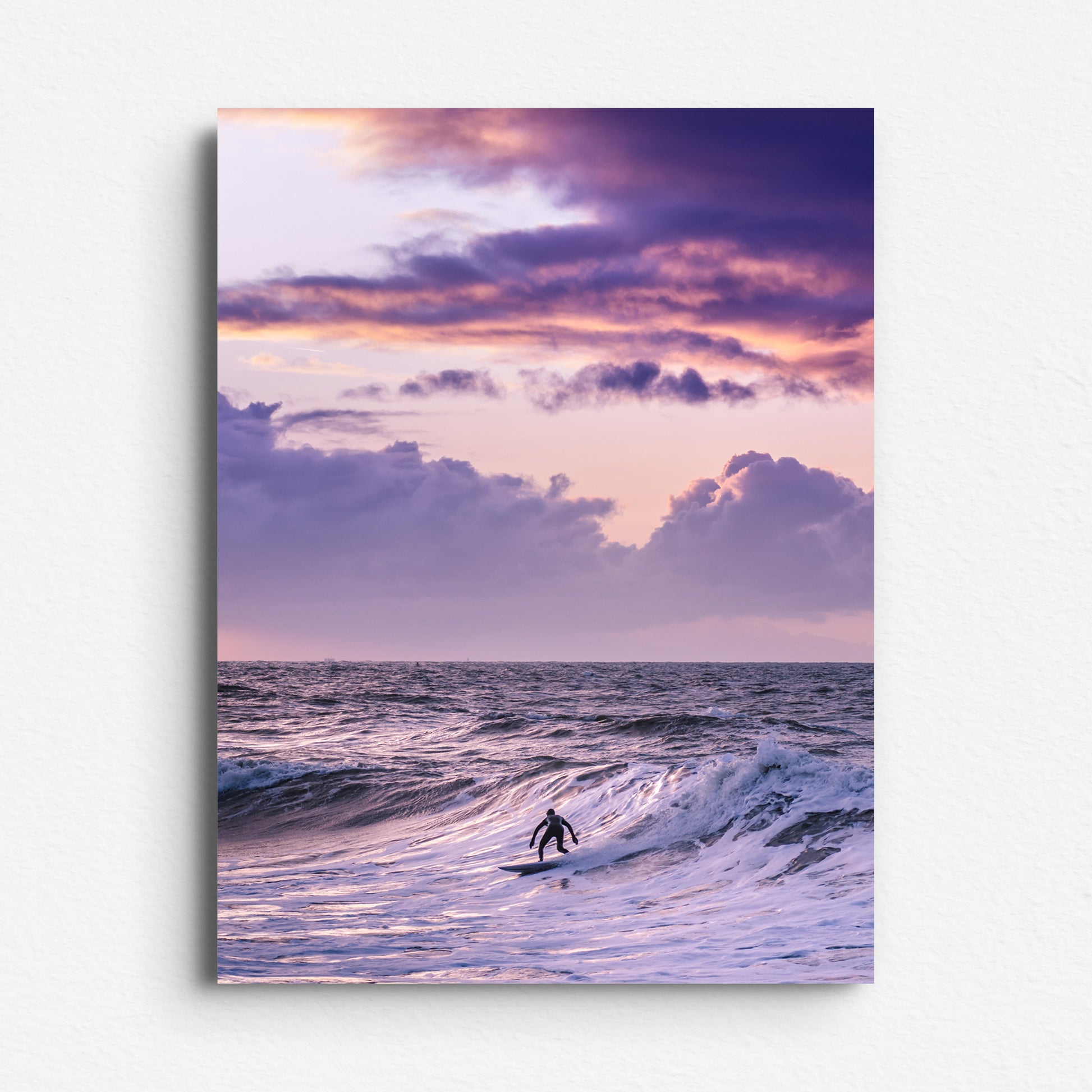 A surfer in Scheveningen beneath a purple sky and dramatic clouds. Printed on Dibond for sleek, modern wall decoration.