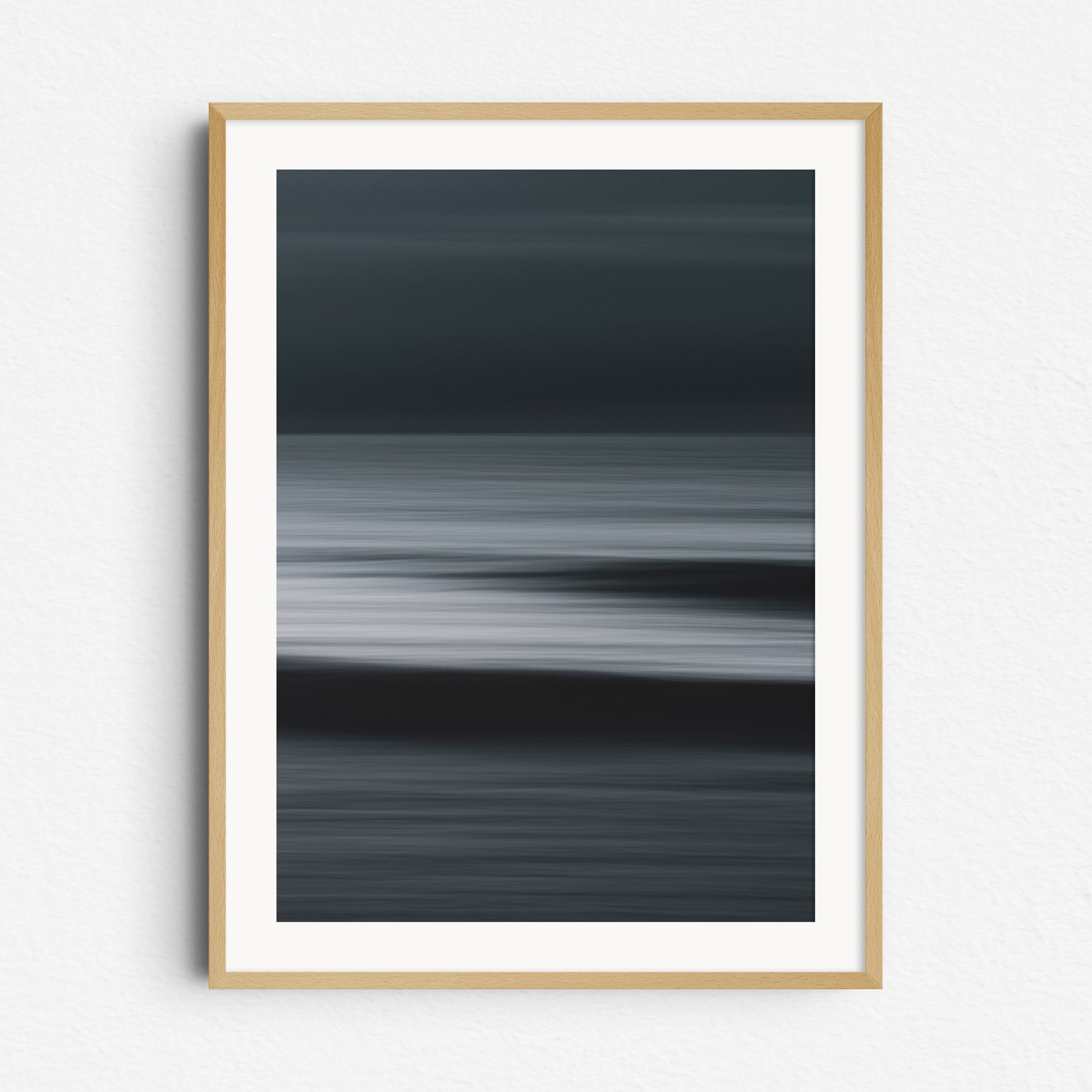 Abstract photo with strong contrasts of the North Sea. Framed in natural wood for a warm, timeless wall decoration.