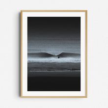 Load image into Gallery viewer, A moody black-and-white photo of a surfer entering the water. Framed in natural wood for a warm, organic touch.
