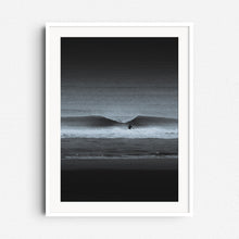 Load image into Gallery viewer, A black-and-white surf scene with a lone surfer and crashing wave. Framed in white wood, ideal for a sleek, minimalist aesthetic.
