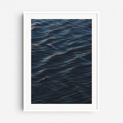 Surf photo art print from The Hague, showcasing a peaceful ocean wave. Print in a white wooden frame.
