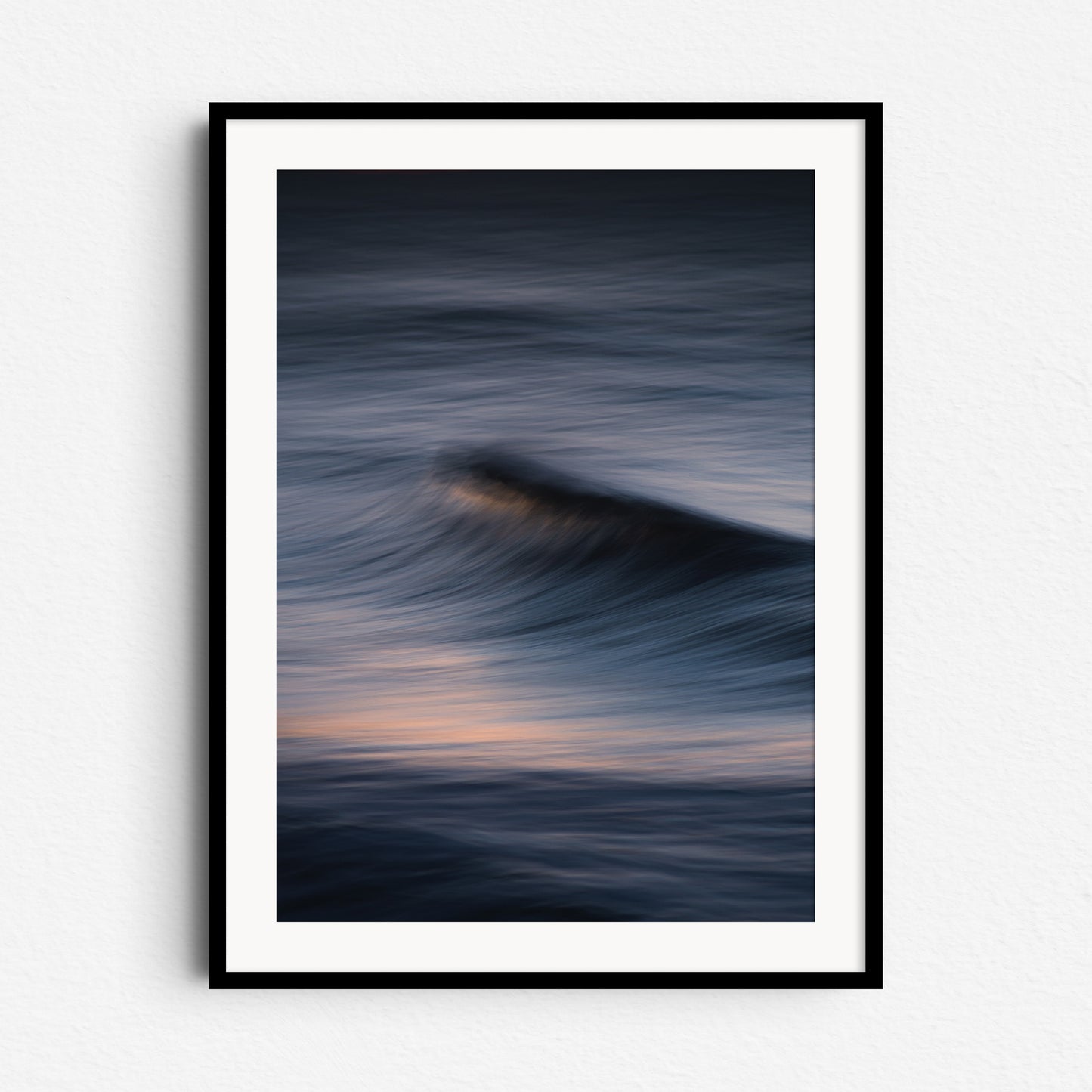 Long exposure photo of a dramatic wave with purple hues. Framed in black wood for bold, modern wall art from The Hague.