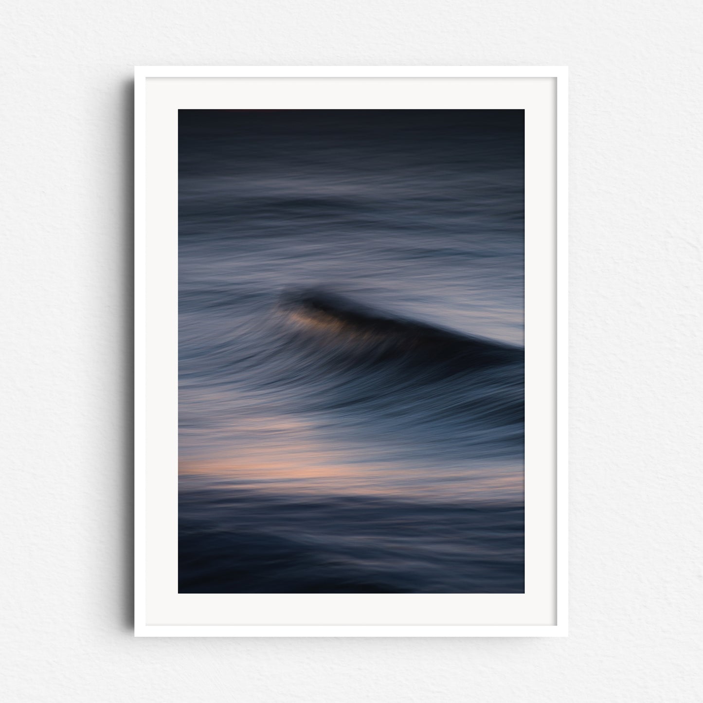 Captivating streaks of light in a North Sea wave. Framed in white wood, this artwork brings light and elegance to your space.