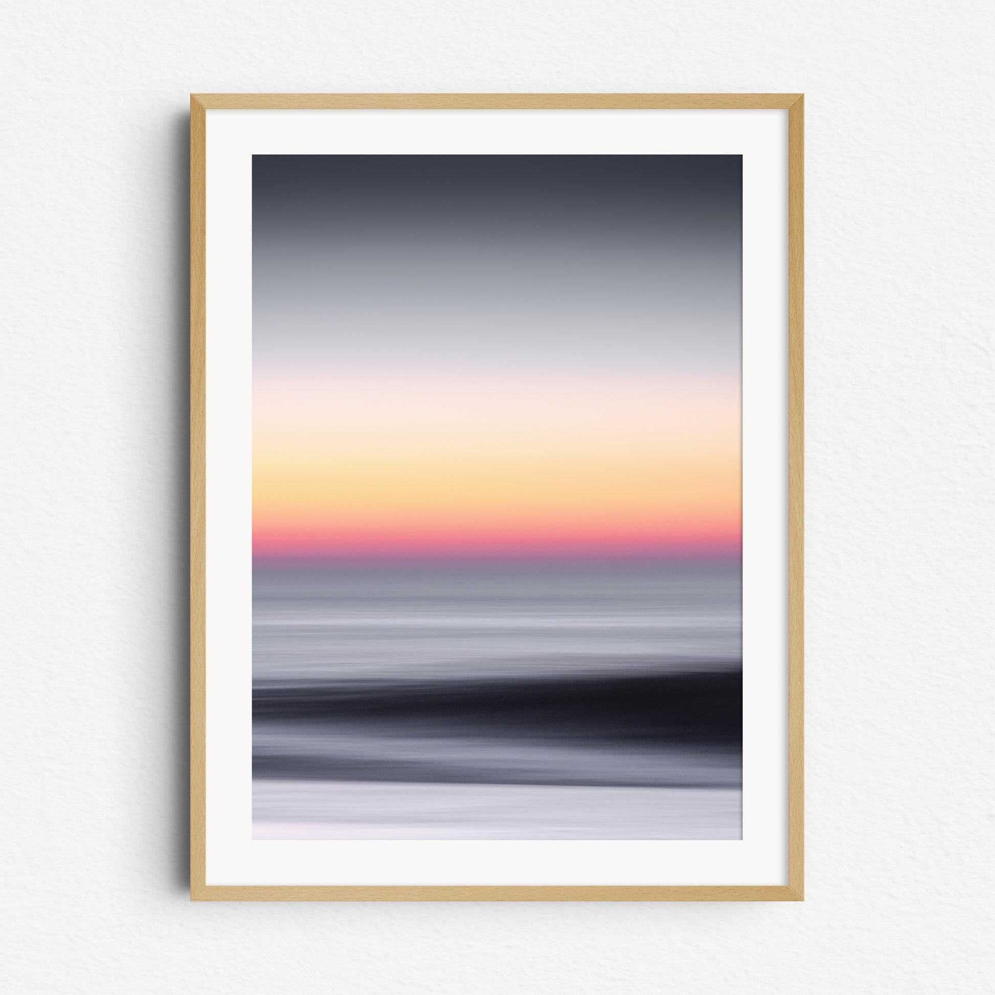 Sunset over the North Sea with orange and grey tones. Abstract, framed in natural wood. Perfect for minimalist coastal interiors.