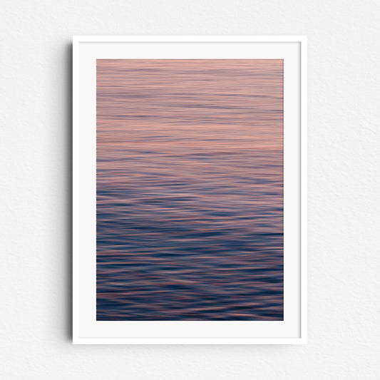 Pastel blues and oranges create a serene North Sea photo. Soft movement, framed in white wood for a calming, modern look.