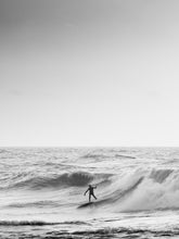 Load image into Gallery viewer, Black and white photograph of a surfer surfing a big wave in the North sea.
