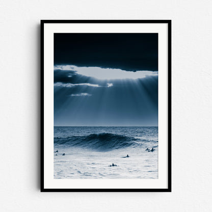 A dramatic surf landscape with sunlight breaking through clouds over the North Sea. Framed in black wood for modern wall art.