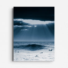 Load image into Gallery viewer, Sunlight pierces heavy clouds over surfers in a blue-toned North Sea scene. Printed on Dibond for sleek, modern wall decoration.
