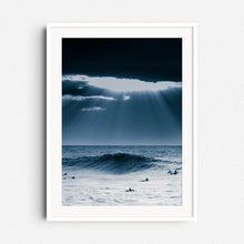 Load image into Gallery viewer, Sunlight bursts through clouds over surfers in the North Sea. Framed in white wood, perfect for a serene and elegant space.
