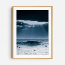 Load image into Gallery viewer, A moody North Sea scene with dramatic clouds and surfers under golden light. Framed in natural wood for a warm, organic aesthetic.
