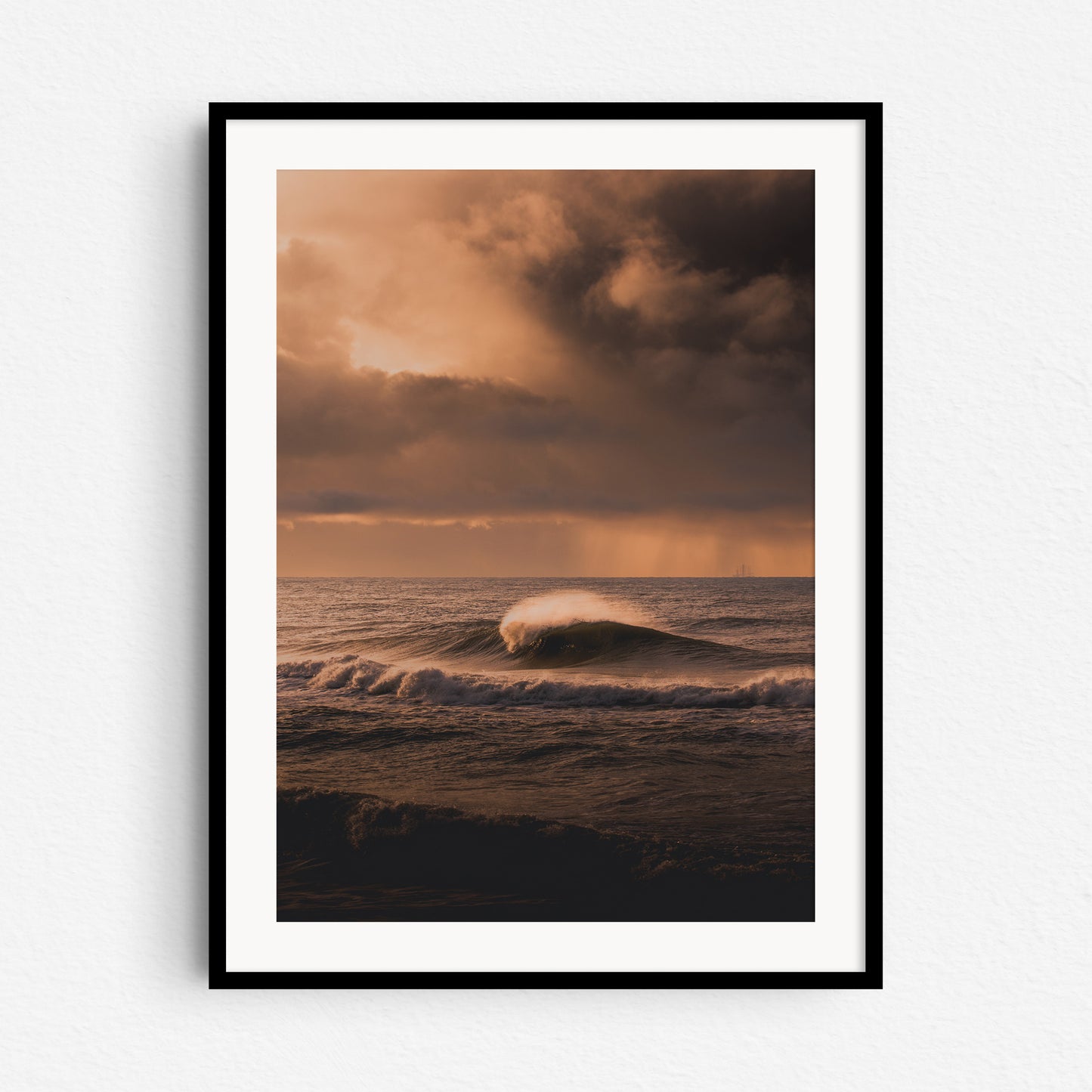 Stormy surf photography from the Netherlands in a black wooden frame.