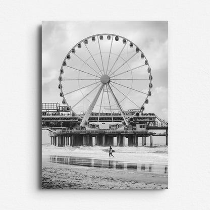 Surfer carrying a shortboard in front of the Scheveningen Pier ferris wheel. Black and white photograph printed on Dibond for a durable and high quality wall art option.