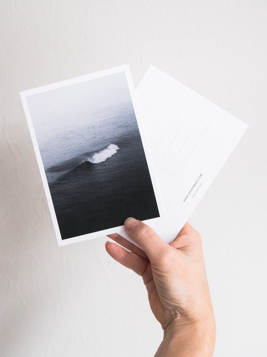 Surf postcard af a North Sea wave held up by a female hand. Photography at the Dutch coast.